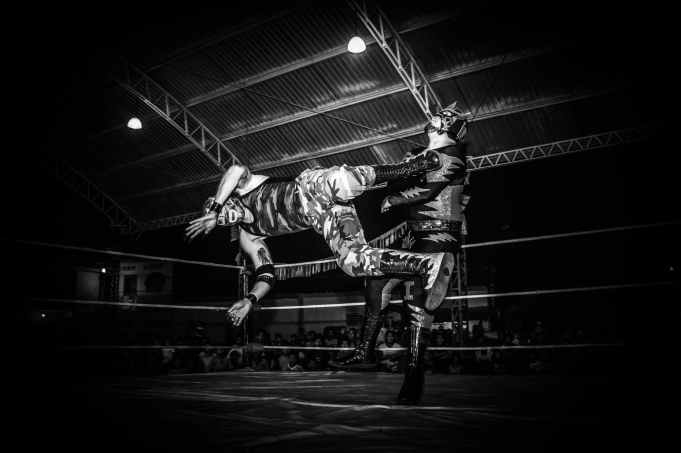 grayscale photography of wrestler on field